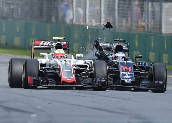 McLaren driver Fernando Alonso, right, of collides with Haas driver Esteban Gutierrez Picture: Theo Karanikos/AP.