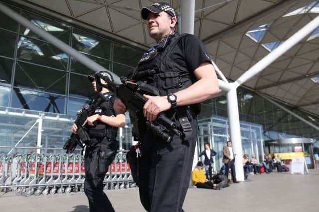Armed police officers patrol outside the terminal building at London Stansted airport, as security has been stepped up at transport hubs in the UK after terrorist bomb attacks in Brussels.