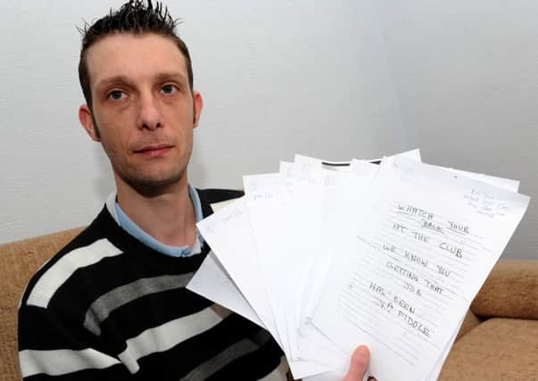 Lee Dean holds up the threatening letters he has received since he has started working at Wadsley Bridge Working Mens Club, Halifax Road. Picture: Andrew Roe