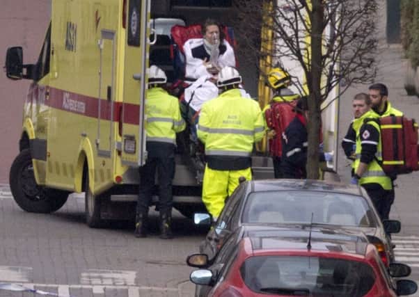 A woman is evacuated in an ambulance by emergency services after a explosion in a main metro station in Brussels on Tuesday, March 22, 2016. Explosions rocked the Brussels airport and the subway system Tuesday, killing at least 13 people and injuring many others just days after the main suspect in the November Paris attacks was arrested in the city, police said. (AP Photo/Virginia Mayo)
