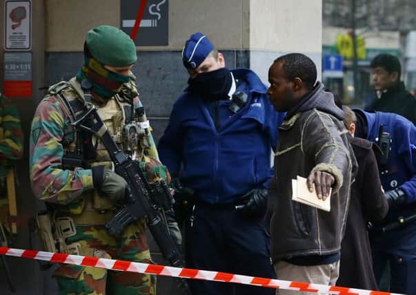 Passengers have their bags checked by armed officers as they arrive to use the Metro at de Brouckere station in Brussels.