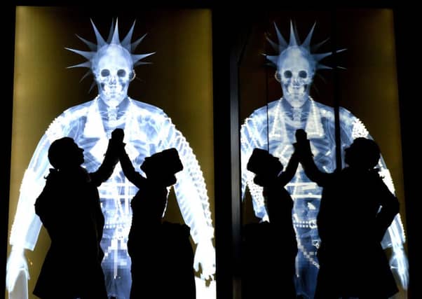 Silhouettes of Lee Clark dressed as a Georgian 'Macaroni' with Eve Haynes dressed in a Victorian Bustle dress against some astwork 'X rays' by Nick Veasey at the new 'Shaping The Body' exhibition at York's Castle Museum .