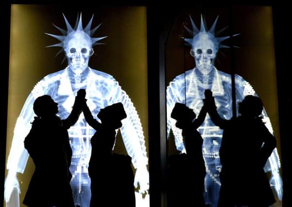 Silhouettes of  Lee Clark dressed as a Georgian 'Macaroni' with Eve Haynes dressed in a Victorian Bustle dress against some  astwork 'X rays' by Nick Veasey  at the new 'Shaping The Body' exhibition at York's Castle Museum .