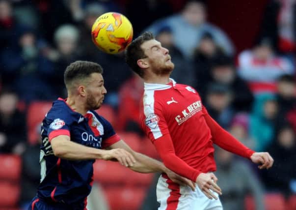 Barnsley's Sam Winnall, heads the ball in mid air with Doncaster Rovers' Aaron Taylor-Sinclaire.