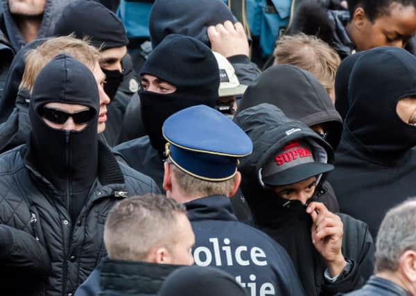 Right wing demonstrators talk with a police man as they protest at a memorial site at the Place de la Bourse in Brussels.