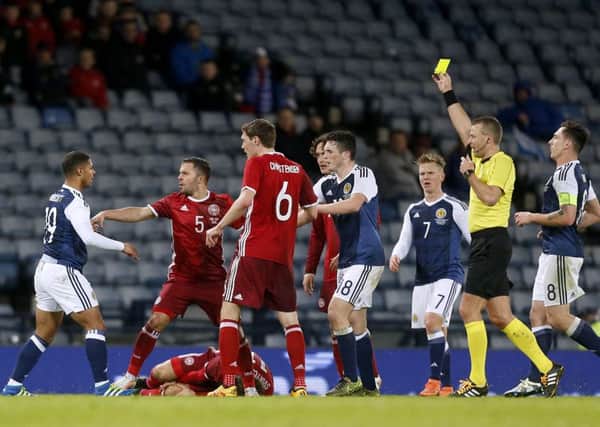 Scotland's Liam Bridcutt (left) is shown the yellow card after fouling Denmark's Erik Sviatchenko. Picture: Danny Lawson/PA.