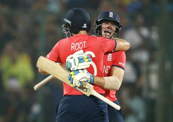 England's Jos Buttler, right, embraces teammate Joe Root after defeating New Zealand.