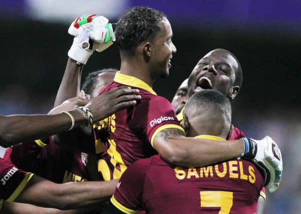 Lendl Simmons is held aloft by West Indies team-mates as they celebrate their seven-wicket win over India (Picture: Rafiq Maqbool/AP).