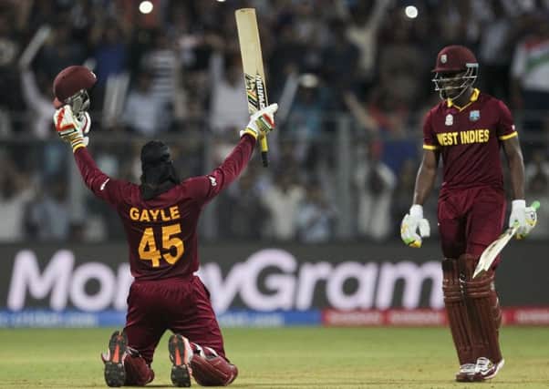 West Indies Chris Gayle raises his bat after scoring a hundred against England.