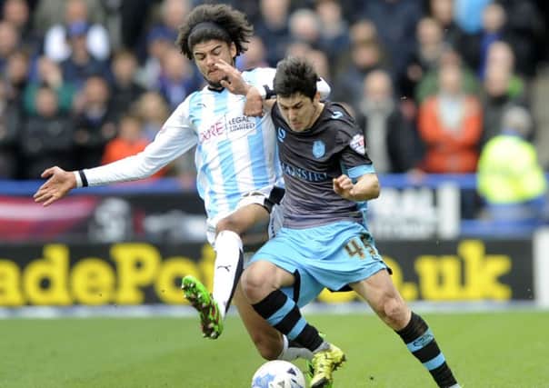 Owls' Fernando Forestieri holds off Huddersfield Town's Philip Billing.