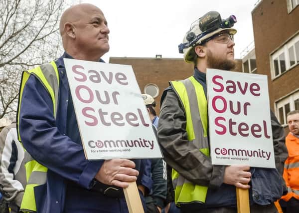 Workers wait to speak to Business Secretary Sajid Javid as he leaves Tata Steel in Port Talbot, South Wales.