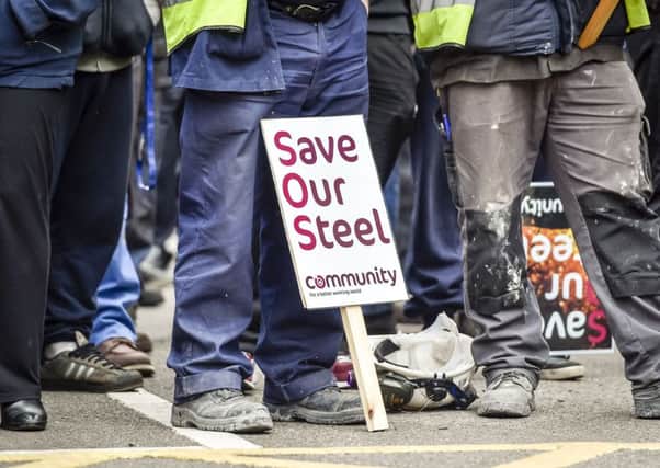 Workers wait to speak to Business Secretary Sajid Javid as he leaves Tata Steel in Port Talbot, South Wales, as the Government outlined its response to the crisis gripping the steel industry.