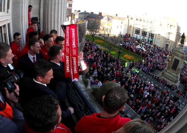 Barnsley players show off the trophy at the town hall