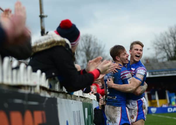 Tom Johnstone celebrates a try with  Jacob Miller.