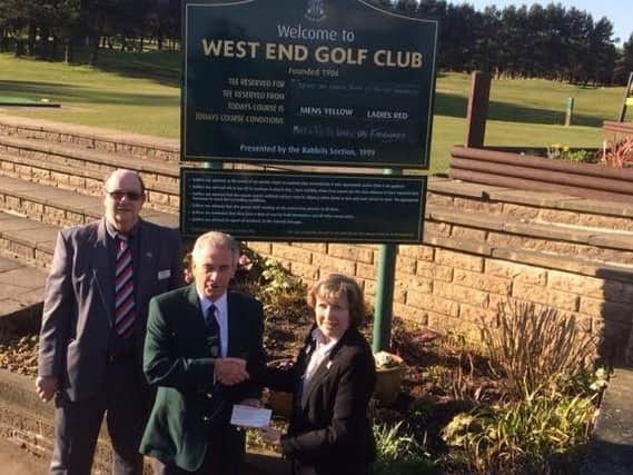 Halifax West End GC's captain Gordon Abernethy, centre, hands over a cheque for 1,200 to Margaret and Nev Smith, from Help For Heroes.
