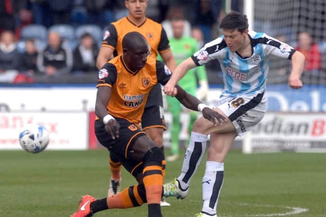 Mo Diame and Joe Lolley of Huddersfield Town battle for the ball.
