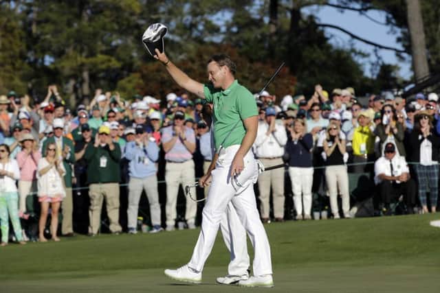 Danny Willett, of England, waves to the gallery after putting out on the 18th hole during the final round of the Masters golf tournament.