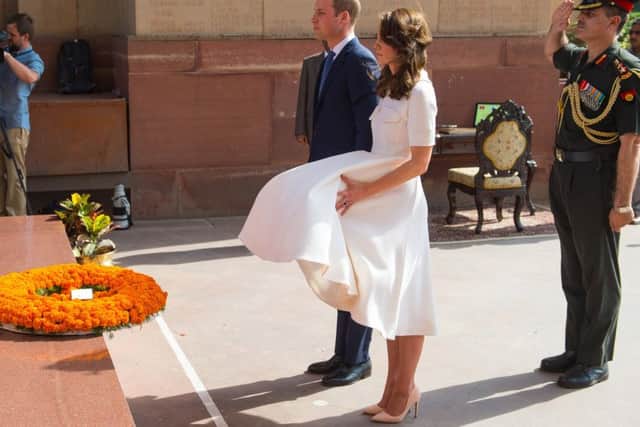 The Duchess of Cambridge struggles to control her dress in strong winds as the Duke and Duchess of Cambridge lay a wreath at the India Gate, in New Delhi, India.  Dominic Lipinski/PA Wire