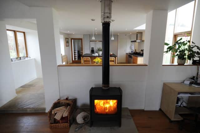 The open plan living space features a cosy wood-burning stove