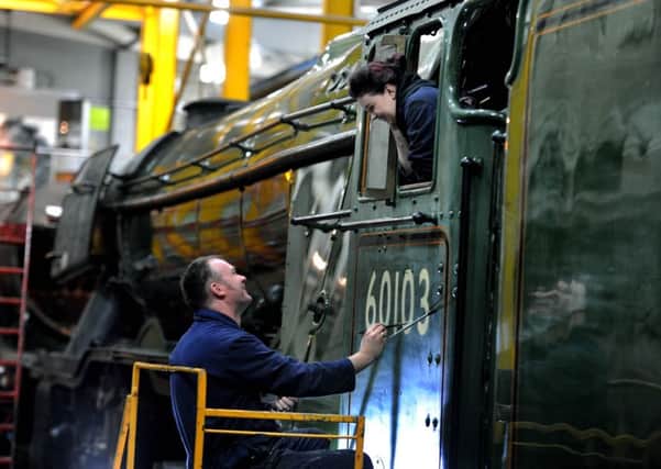 Mike O'Connor, from the Heritage Painting Team at the National Railway Museum, York, painting the number on the side of Flying Scotsman cab, watch by daughter Teriann, aged 21. Picture: James Hardisty.