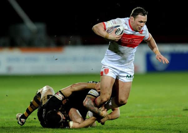 Hull KR's Shaun Lunt is tackled by Catalans defence.
