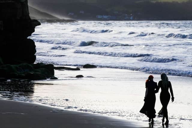 Two goths walk along the beach at dusk on Whitby Goth Weekend. April 23 2016. Picture: Ceri Oakes w161751t