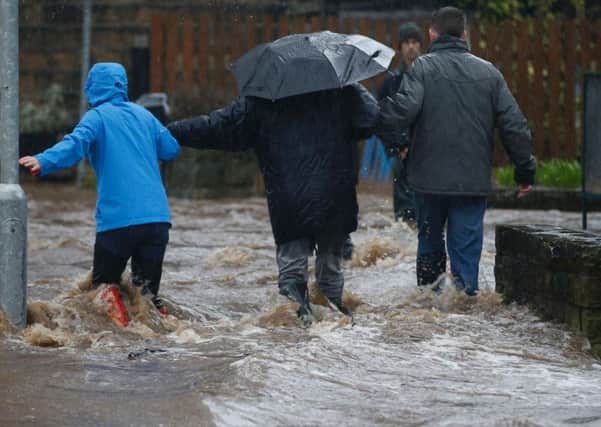 People wade through flood waters at Mytholmroyd in Calderdale during the December floods. (PA)
