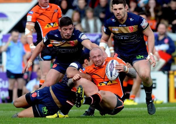 Castleford player Nathan Massey is held by the Hull KR defence.