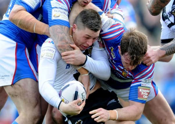 Hull's Jamie Shaul is wrapped up by the Wildcats defence.