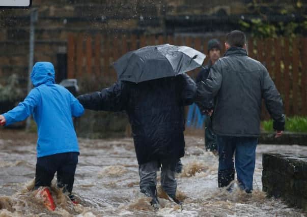 People wade through flood waters