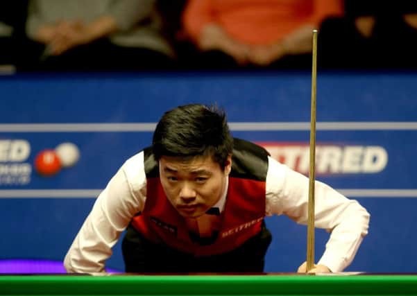 Ding Junhui surveys the layout of the balls ahead of a shot during his World Championship match against world No 5 Judd Trump (Picture: Richard Sellers/PA).