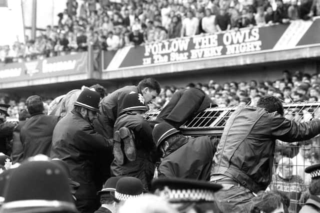 Flashback to 1989: Police help fans over the fencing as the crush intensifies