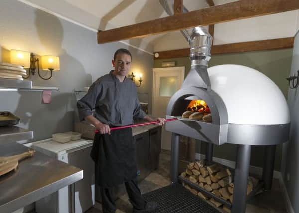Cameron Reid, landlord of The New Inn, Tholthorpe, near Easingwold, next to the new pizza oven.  Pic: James Hardisty.