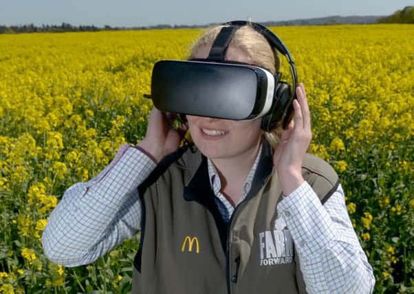 McDonald's Progressive Young Farmer Alice Partridge, 21, wears an Oculus Virtual Reality headset in rape seed field