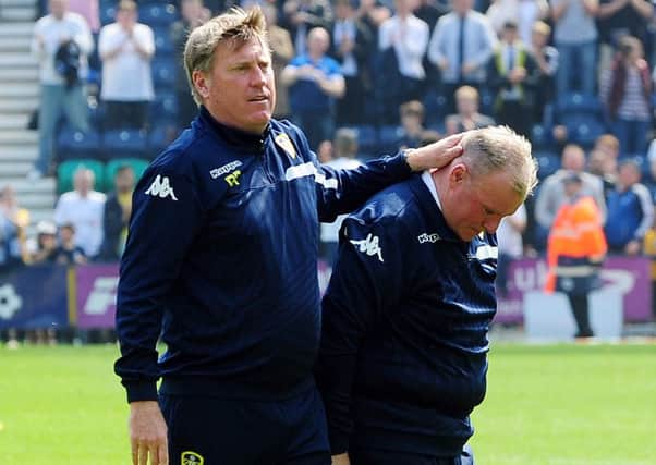 Leeds United head coach Steve Evans is consoled by assistant Paul Raynor at the end.
