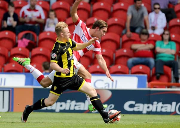 Burton Albion's Mark Duffy (left) and Doncaster Rovers' Mitchell Lund battle for the ball at the Keepmoat Stadium. Picture: Richard Sellers/PA Wire.