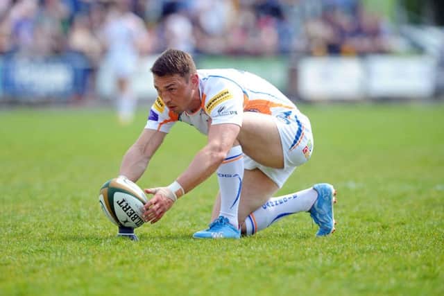 Kevin Sinfield places the ball in his last match