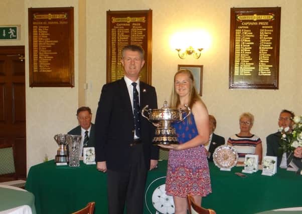 Megan Garland receives the trophy from Yorkshire Union of Golf Clubs president Jonathan Plaxton after winning the county championship at Huddersfield GC.