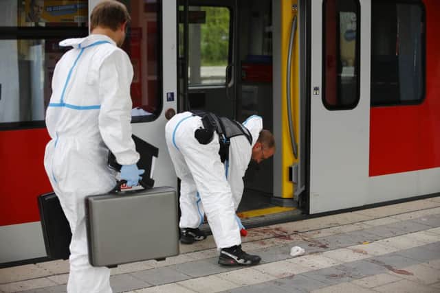 Police investigators at the site of a stabbing at a station in Grafing near Munich