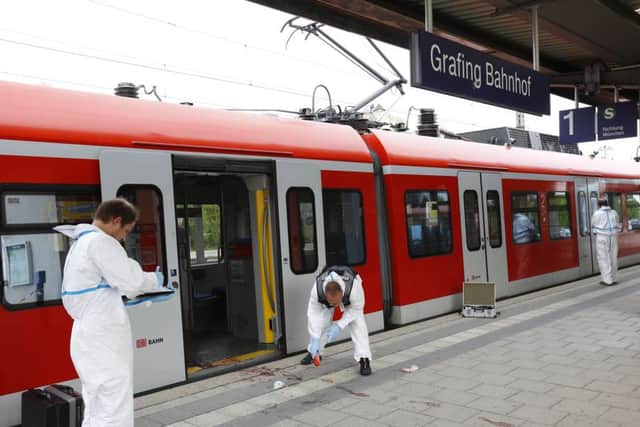 Police investigators at the site of a stabbing at a station in Grafing near Munich