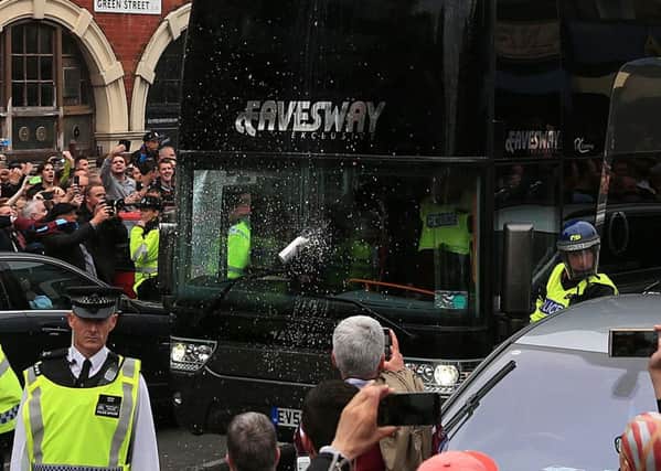 A can is thrown towards the Manchester United coach as it arrives for the Barclays Premier League match at Upton Park, London.