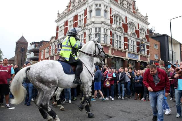 Fans are controlled by police outside Upton Park before the Barclays Premier League match at Upton Park, London.