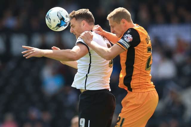 Derby County's Chris Martin (left) and Hull City's Michael Dawson battle for the ball during the Sky Bet Championship playoff, first leg match at the iPro Stadium, Derby.
