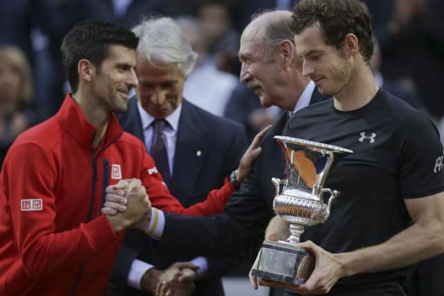 Andy Murray holds the trophy, with Novak Djokovic offering congratulations. Picture: AP