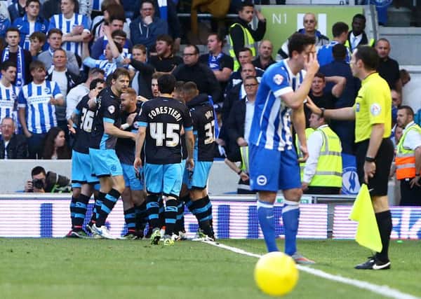 Ross Wallace, obscured, celebrates Sheffield Wednesdays equaliser as Brightons Lewis Dunk appeals in vain for a free-kick for pushing (Picture: Gareth Fuller/PA).