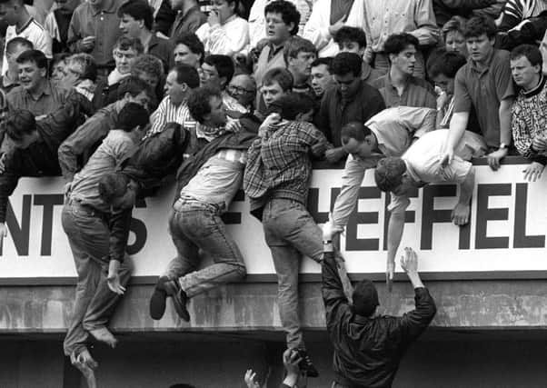 Football fans climb to safety as they escape the crush which claimed the lives of 96 Liverpool fans at the 1989 FA Cup semi-final at Hillsborough.