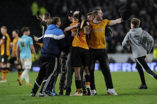 Abel Hernandez is hugged by fans after Hull City reached the Championship play-off final on aggregate despite last nights 2-0 home loss to Derby (Picture: Bruce Rollinson).