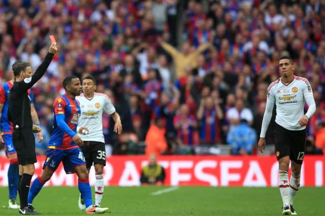 Manchester United's Chris Smalling (right) is shown a red card by referee Mark Clattenburg. Picture: Nick Potts/PA
