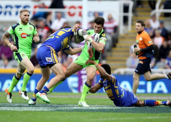 Wigan Warriors' Oliver Gildart is tackled by a desperate Leeds Rhinos defence. Picture: Richard Sellers/PA