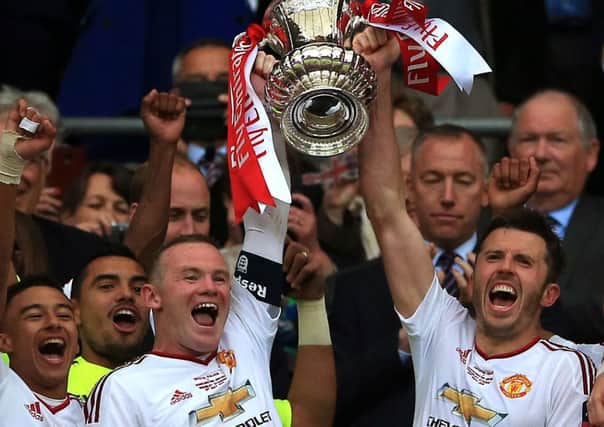 Manchester United's Wayne Rooney, left, and Michael Carrick lift the FA Cup after victory over Crystal Palace (Picture: Nick Potts/PA Wire).